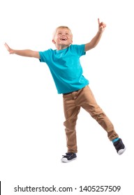 HAPPY BOY WITH OUTSTRETCHED HANDS AND POINTING FINGER STANDING ON ONE LEG AND LOOKING UP WHILE BALANCING ISOLATED ON WHITE BACKGROUND