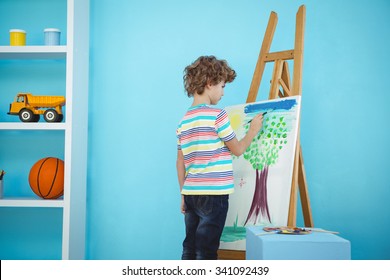 Happy Boy Painting His Picture On An Easel