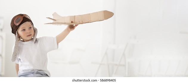 Happy Boy Play With Paper Airplane In Hand, Child Dreams About Traveling By Aeroplane