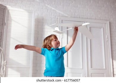 Happy Boy Play With Paper Airplane In Hand, Child Dreams About Traveling By Aeroplane