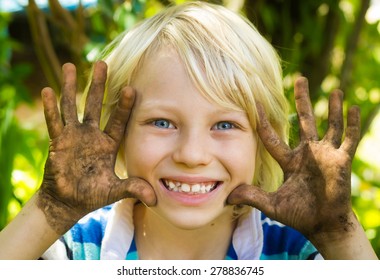 Happy Boy Playing Outside With Dirty Hands