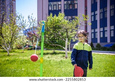 Happy boy is playing tetherball swing ball game in summer camping. Happy leisure healthy active time outdoors concept.