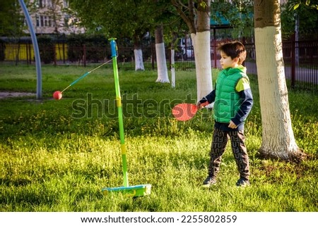 Happy boy is playing tetherball swing ball game in summer camping. Happy leisure healthy active time outdoors concept.