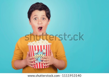 Similar – surprised boy with popcorn and television remote control on blue background