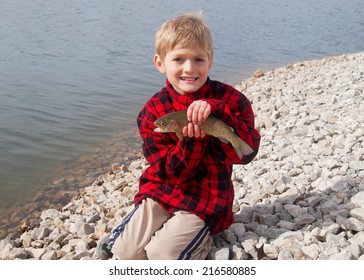 Happy Boy And A Rainbow Trout Fish Caught Fly Fishing At A Lake