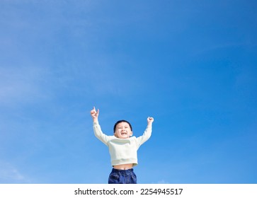 Happy boy reaching up to the sky - Shutterstock ID 2254945517