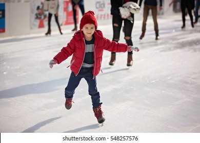 Happy boy with red hat and jacket, skating during the day, having fun