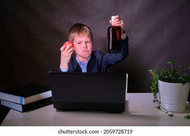 Ein glücklicher Junge in einem Schulanzug mit einer Flasche Alkohol in den Händen, Kopienraum auf dunklem Studiohintergrund
