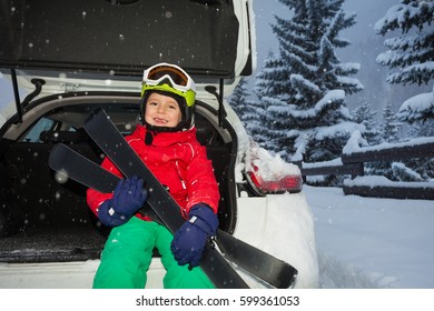 Happy Boy Sitting In Car Trunk After Ski Trip