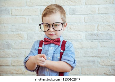 Happy boy standing with a finger in big glasses. The concept of the good boss - Shutterstock ID 1150102847