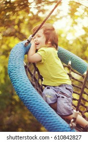 Happy boy swinging on a swing in the Park on a Sunny summer day