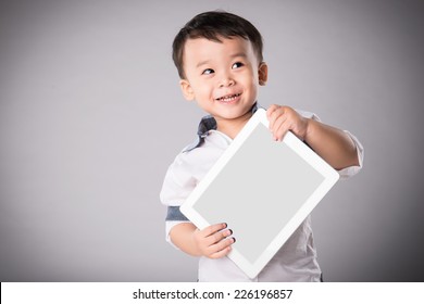 Happy Boy With Tablet Computer. Child Showing Tablet. Little Asian Boy Smiles With Tablet Computer On Isolated Background