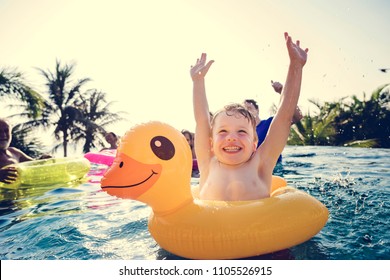 Happy boy and a yellow duck tube in the pool