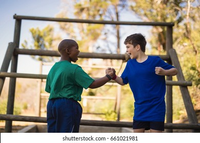 Happy boys cheering during obstacle course in boot camp - Powered by Shutterstock