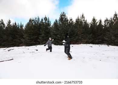 Happy Boys Playing In Snowy Winter Wonderland Having Snowball Fight