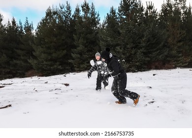 Happy Boys Playing In Snowy Winter Wonderland Having Snowball Fight