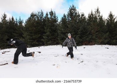 Happy Boys Playing In Snowy Winter Wonderland Having Snowball Fight