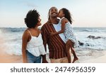 A happy Brazilian family shares a joyous moment together on a beautiful beach during their vacation.