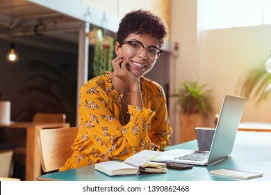 Happy Brazilian Girl With Eyewear In Coworking Office With Laptop Looking At Camera. Smiling African American Student Using Computer At Cafeteria. Successful Young Stylish Business Woman With Glasses.