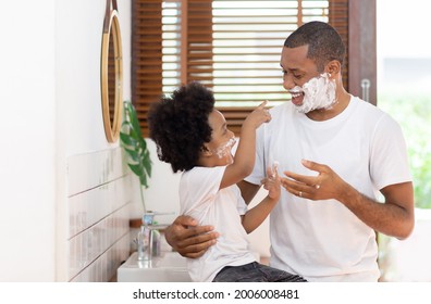 Happy Brazilian Single Father and little son having fun with shaving foam on their faces in bathroom at home together. Black African American enjoying on holidays. - Powered by Shutterstock