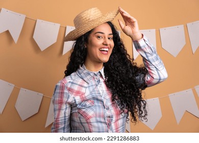 happy brazilian woman to Festa Junina in Brazil in beige background. smiling and looking at camera - Powered by Shutterstock