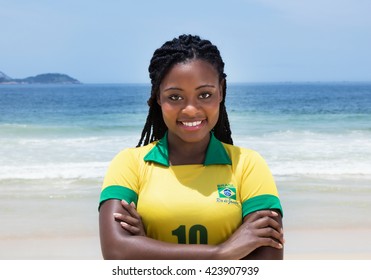 Happy Brazilian Woman In A Soccer Jersey At Beach Outdoor At Beach With Ocean And Blue Sky In The Background