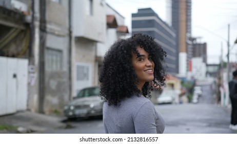 A happy Brazilian woman turning towards camera smiling