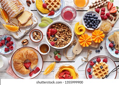 Happy breakfast with granola, croissant, fresh waffles, fruits and berries. 