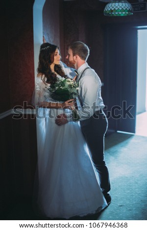Happy bride and bearded groom on the wedding walk in the modern hotel hall on wedding