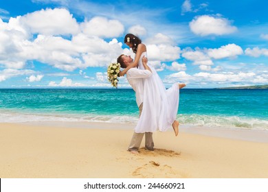happy bride and groom having fun on a tropical beach