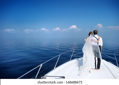 Happy bride and groom hugging on a yacht