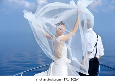 Happy bride and groom hugging on a yacht