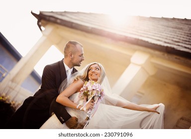 Happy Bride And Groom Posing By The Old House