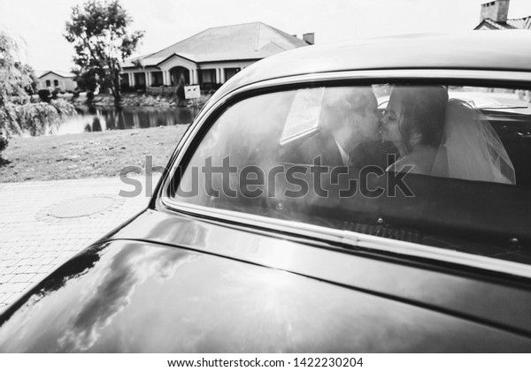 Happy brides are kissing in\
the car