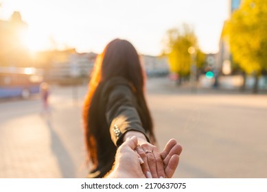 Happy Brunette Girl Turn Away Face Holding Boyfriend's Hand On A Street At Sunset On A Warm Spring,summer Evening.Follow-me Concept.Selective Focus.