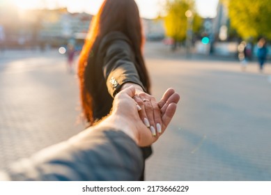 Happy Brunette Girl Turn Away Face Holding Boyfriend's Hand On A Street At Sunset On A Warm Spring,summer Evening.Follow-me Concept.Selective Focus.