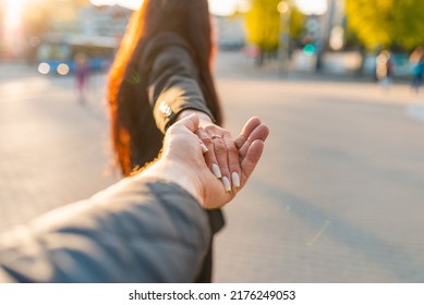 Happy Brunette Girl Turn Away Face Holding Boyfriend's Hand On A Street At Sunset On A Warm Spring,summer Evening.Follow-me Concept.Selective Focus.