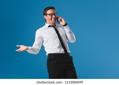 Happy Buisnessman In Eyeglasses Laughing While Talking By Smartphone Isolated On Blue