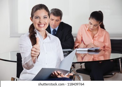 Happy busines woman with files in office holding her thumbs up - Powered by Shutterstock