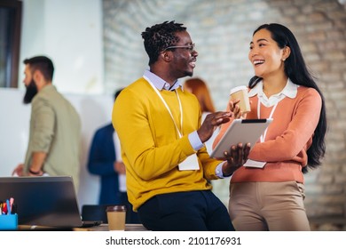 Happy business colleagues using digital tablet while standing in a lobby. - Powered by Shutterstock