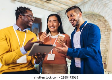 Happy business colleagues using digital tablet while standing in a office - Powered by Shutterstock