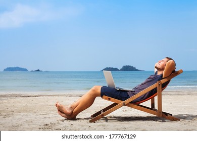 Happy Business Man With Laptop Relaxing On The Beach