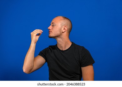 Happy Business Man Licking Fingers Isolated On Blue Studio Background. Beautiful Male Half-length Portrait. Young Satisfy Man. Human Emotions, Facial Expression Concept. Front View.