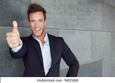 Happy Business Man In Urban City Holding Thumbs Up