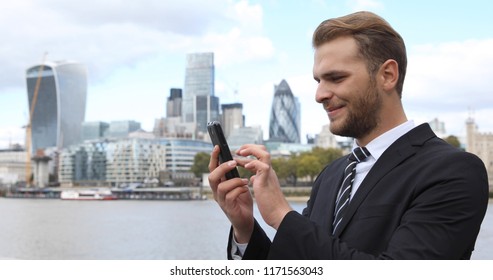 Happy Business Man Working on Mobile Phone Surfing Internet in London Skyline City Center