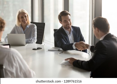 Happy business partners shaking hands expressing respect, closing banking investment corporate deal, welcoming at office group meeting, handshake of smiling businessmen as collaboration concept - Shutterstock ID 1289761516