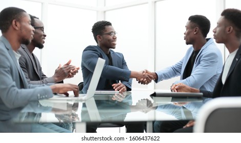 happy business partners shaking hands at meeting in the office.