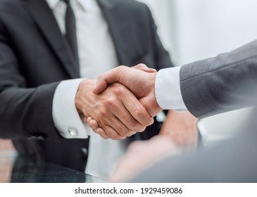 happy business partners shaking hands at the negotiating table. - Shutterstock ID 1929459086