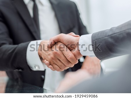 happy business partners shaking hands at the negotiating table.