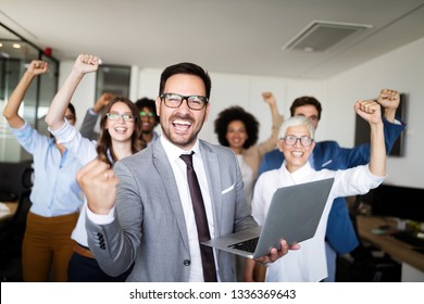 Happy business people celebrating success at company - Shutterstock ID 1336369643